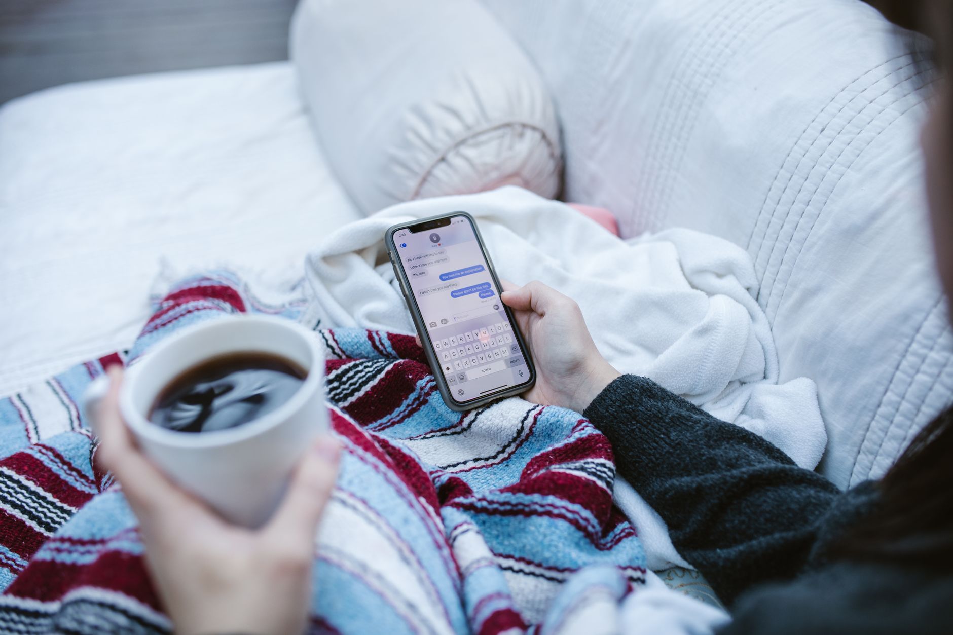 a person holding a smartphone and taking a screenshot of a chat conversation