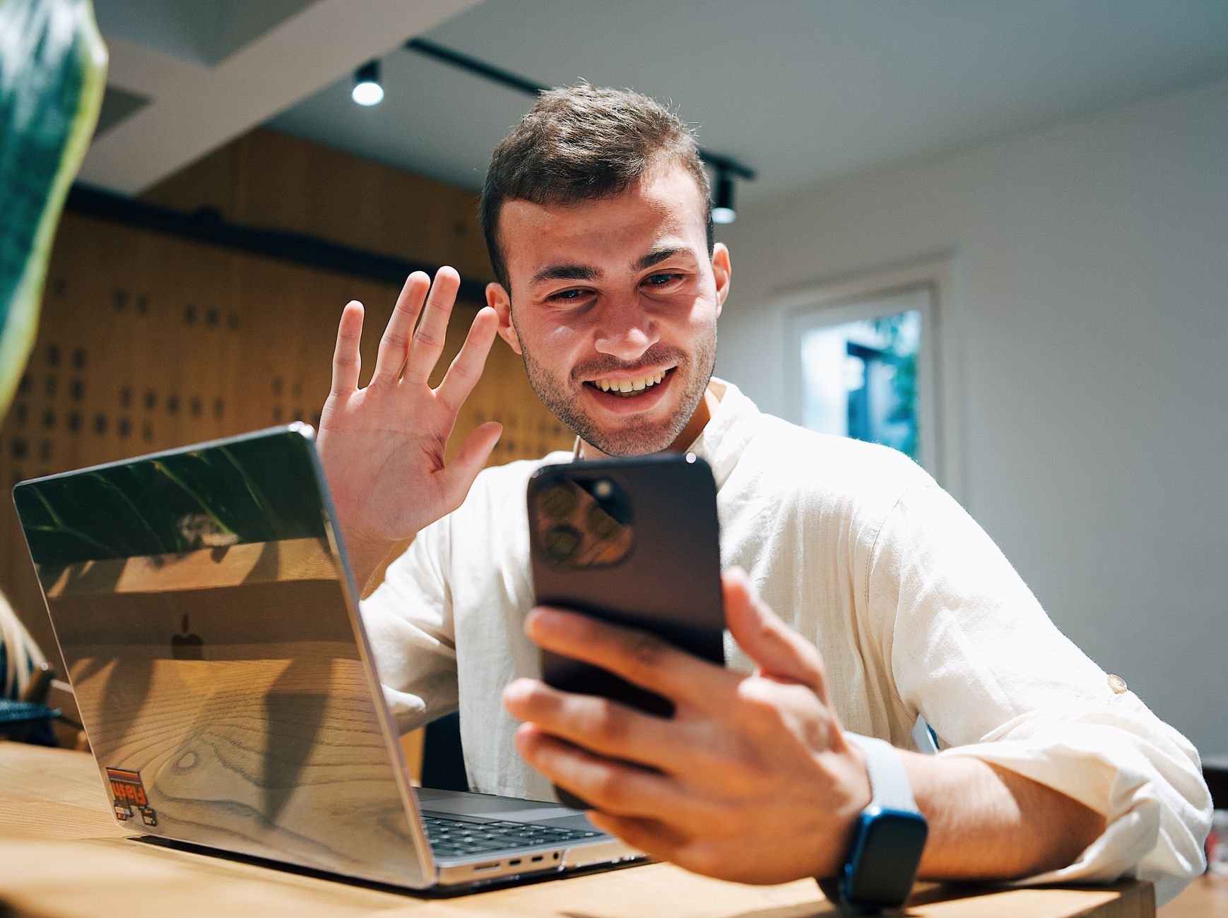 A person using a laptop and smartphone to save screenshots and video evidence