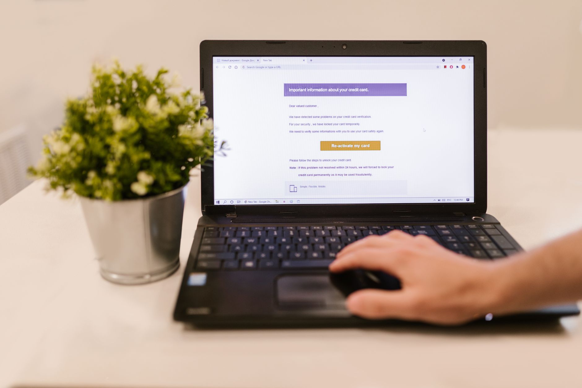 A person using a laptop to freeze their credit while holding a credit card and documents