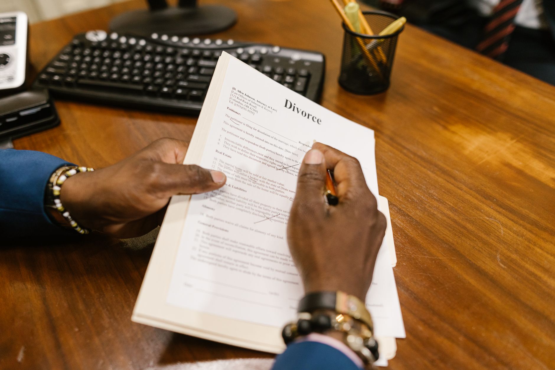 a person signing legal documents at a desk with a gavel and lawsuit papers
