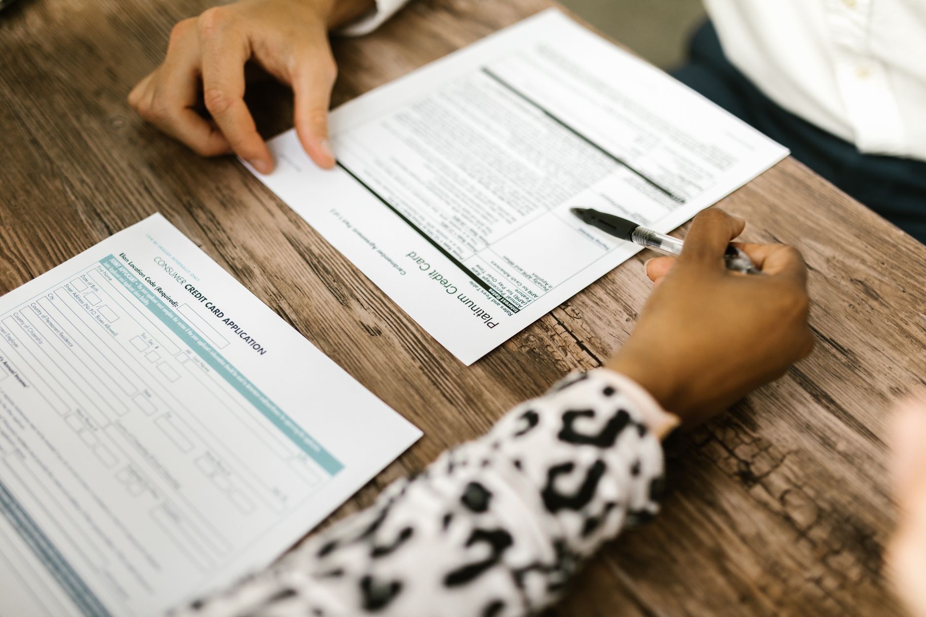 A person placing a credit freeze confirmation letter on a desk next to a credit report